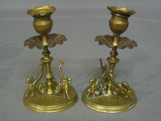 A pair of 19th Century copper and brass candlesticks supported by figures of griffins 6"