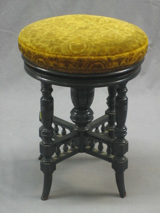 A Victorian ebonised and revolving circular adjustable piano stool, raised on turned supports with X framed stretcher