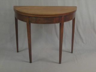 A 19th Century mahogany demi-lune tea table with ebony and satinwood crossbanding, raised on square tapering supports 46"