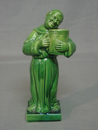 A Continental green glazed pottery figure of a standing monk with flagon 10"