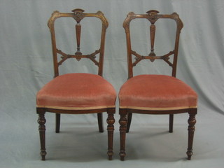 A set of 4 Victorian carved walnut slat back dining chairs, the seats upholstered in pink Dralon and raised on turned and reeded supports
