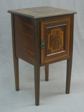 An Edwardian inlaid mahogany pot cupboard enclosed by a panelled door, raised on square tapering supports 16"