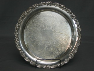 A circular silver plated salver with engraved decoration and cast floral border 15"