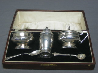 An Art Deco 3 piece silver condiment set comprising mustard, pepper and salt, Birmingham 1928 3 ozs together with 2 associated spoons, cased
