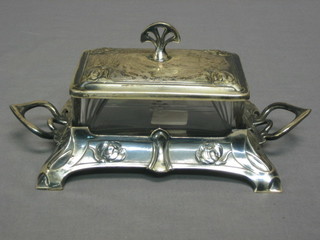 A WMF twin handled butter dish and cover with glass liner, raised on 4 planished supports