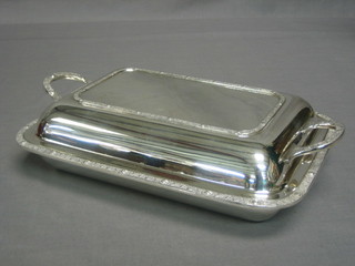 An oval silver plated twin handled entree dish and cover by Garrards