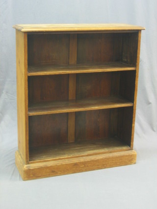 A Victorian stripped and polished pine 3 tier bookcase, raised on a platform base 31"