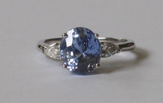 An 18ct white gold dress ring set an oval sapphire supported by diamonds