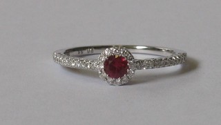 An 18ct white gold dress ring set a ruby and with numerous diamonds to the shoulders