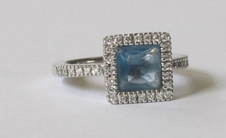 An 18ct white gold dress ring set a blue topaz surrounded by diamonds