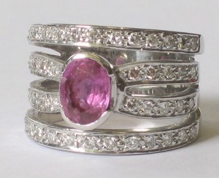 An 18ct white gold 4 band dress ring, set an oval pink sapphire supported by diamonds