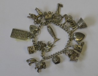 A silver curb link charm bracelet hung numerous charms