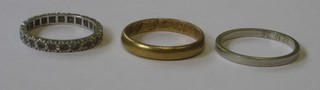 A 14ct white gold wedding band, a gilt wedding band and an eternity ring