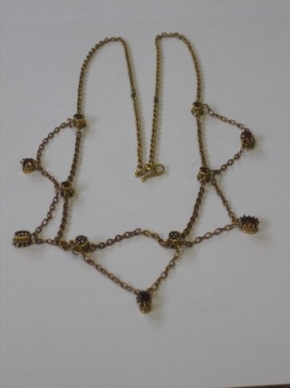A gilt metal chain set red stones