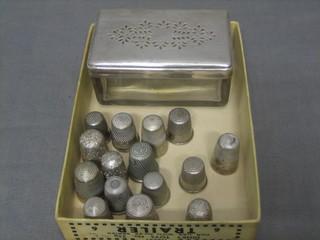 A rectangular 19th Century cut glass dressing table jar with pierced silver plated lid together with 3 silver thimbles and 12 others