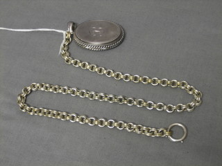 An oval engraved silver locket and a white metal belcher link chain