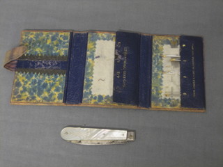 A silver bladed folding fruit knife with mother of pearl grip together with a leather wallet containing a collection of various needles
