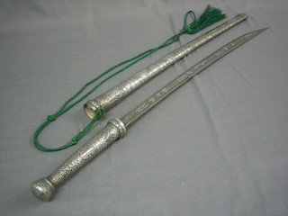 An Eastern sword with etched blade depicting Tiger hunting scenes contained in a silver scabbard