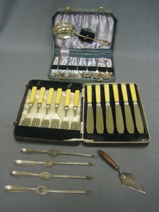 A set of 6 silver plated fish knives and forks, a set of 6 silver plated fruit spoons, 4 Lobster picks and a silver plated butter knife in the form of a trowel