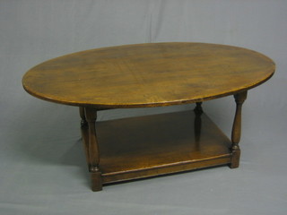 A 17th Century style oak oval coffee table, raised on turned and block supports with rectangular undertier 47"