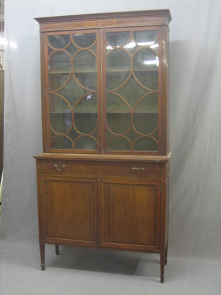A 19th Century inlaid mahogany bookcase on cabinet the upper section fitted shelves enclosed by astragal glazed doors, the base fitted 1 long drawer with cupboard enclosed by panelled doors, raised on square supports 39"
