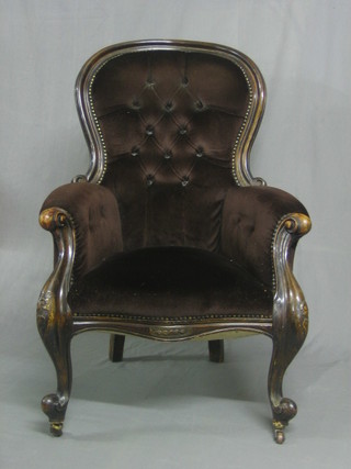 A Victorian mahogany show frame armchair upholstered in brown buttoned material raised on cabriole supports