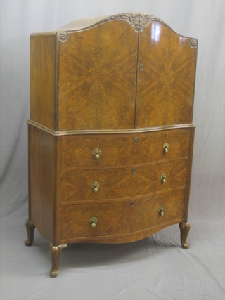 A 1930's Art Deco figured walnut tall boy of serpentine outline, with fitted interior enclosed by panelled doors the base fitted 3 drawers, raised on cabriole supports 36"