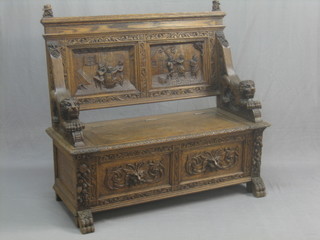 A Victorian carved honey oak settle decorated tavern scenes with lion head arm rests 46"
