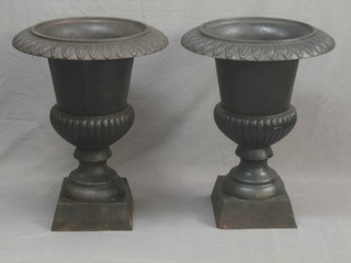A pair of Victorian circular cast iron trumped shaped urns with cast borders and lobed bodies, raised on square feet (removed from a former Sussex School) 29"