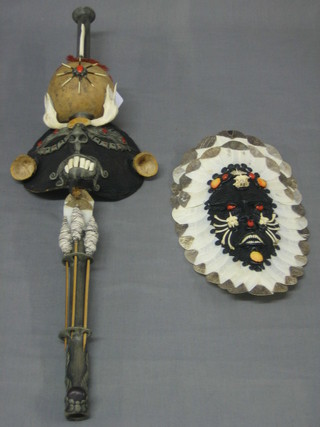 An Eastern hardwood mask decorated darts and inset teeth 26" together with a similar oval mask with shell decoration 11" (2)