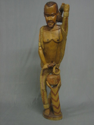 A large carved wood figure of a native with mallet 54"