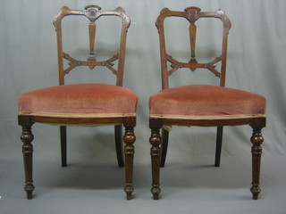 A set of 4 Victorian carved walnut slat back dining chairs, the seats upholstered in pink Dralon and raised on turned and reeded supports