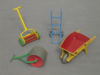 A Dinky lawn mower 105E? and do. wheel barrow 105B, a pair of porters wheels and a garden roller