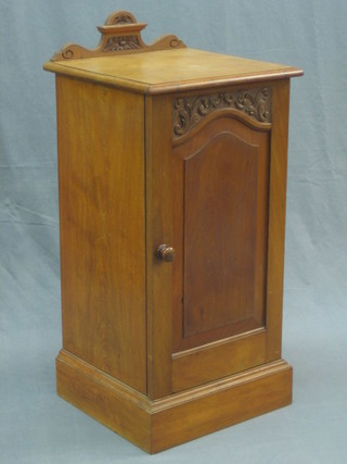 A Victorian bleached walnut pot cupboard with raised carved back enclosed by a panelled door 16"