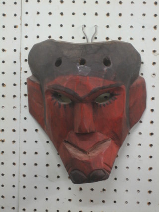 A carved Eastern red and black painted mask