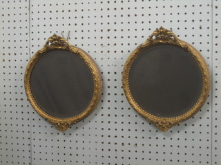 A pair of 19th Century circular bevelled plate wall mirrors contained in a decorative gilt frame with swag decoration 7 1/2"