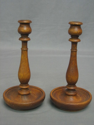 A pair of turned oak candlesticks 9"