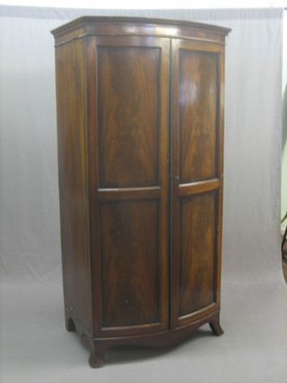A Georgian style mahogany bow front wardrobe with moulded cornice the interior fitted a drawer to the base enclosed by arch panelled doors, raised on splayed bracket feet 32"