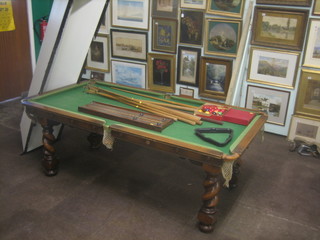 An Edwardian oak slate based quarter size billiard table, raised on spiral turned and block supports 66", complete with score board, lamp, 2 sets of balls and cues