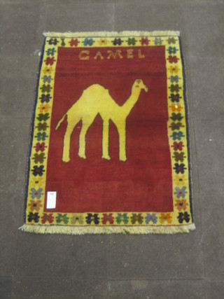 A contemporary red ground Persian rug the centre decorated a standing camel 54" x 38"