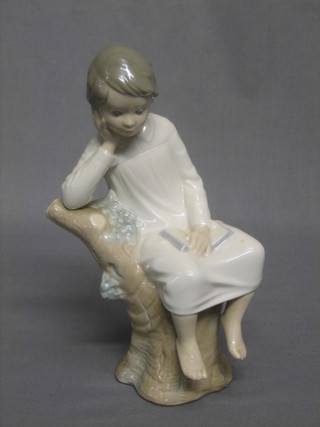 A Lladro figure of a seated boy in night shirt 8"
