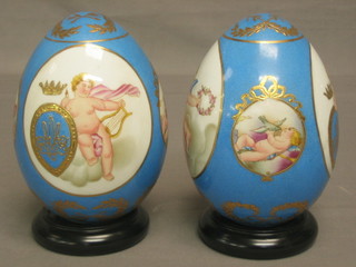 A pair of 20th Century Sevres style porcelain models of eggs decorated cherubs etc 6"