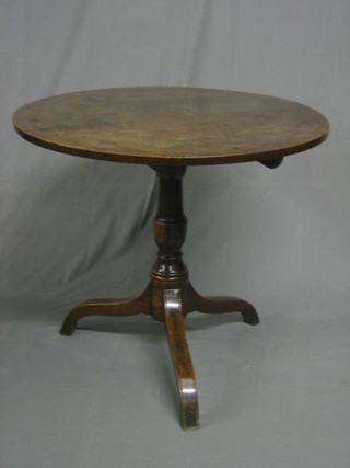 An 18th/19th Century circular oak tea table raised on pillar and tripod supports 13"