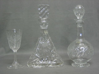 An etched glass wine glass, a triangular shaped decanter and stopper and a club shaped decanter and stopper