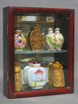 An Eastern hardwood display cabinet containing 6 miniature reproduction snuff bottles