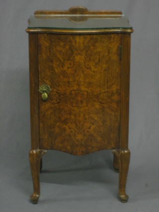 A Continental figured walnut serpentine fronted bedside cabinet, raised on cabriole supports 16"
