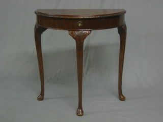 A Georgian style carved mahogany demi-lune hall table fitted a frieze drawer and raised on cabriole supports 28"