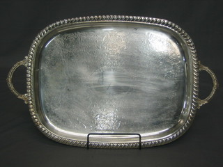 An oval silver plated tea tray with gadrooned border, raised on 4 panelled feet 22"