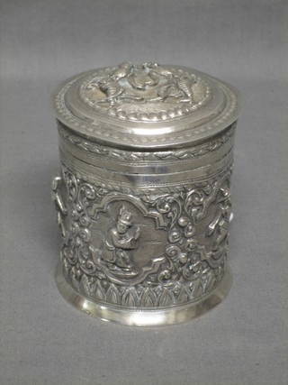 An Eastern cylindrical embossed silver jar and cover decorated figures 4", some holes to lid