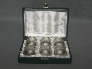 6 Eastern embossed white metal napkin rings, cased